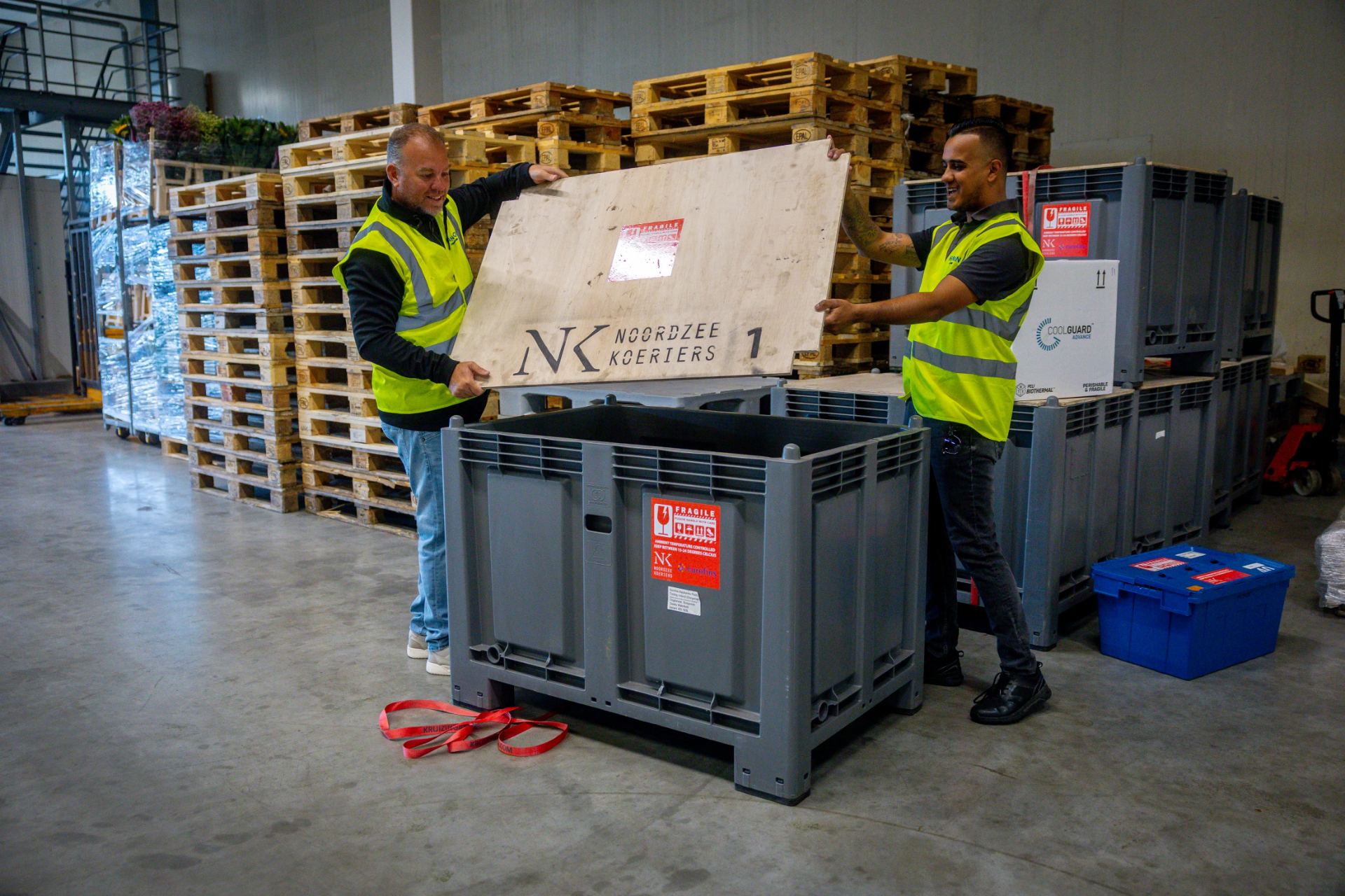 Koeriers sluiten een palletbox in het magazijn